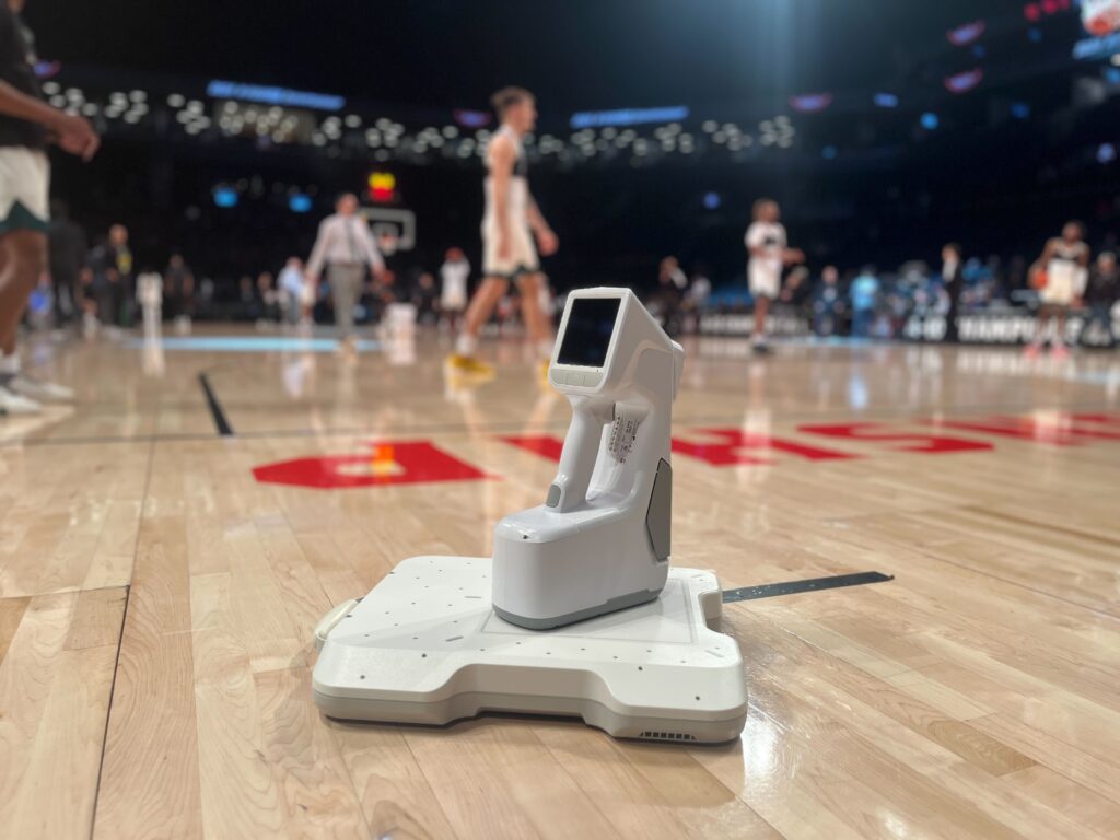 MC2 Portable X-ray use in sports medicine, on a basketball court with athletes practicing in the background.