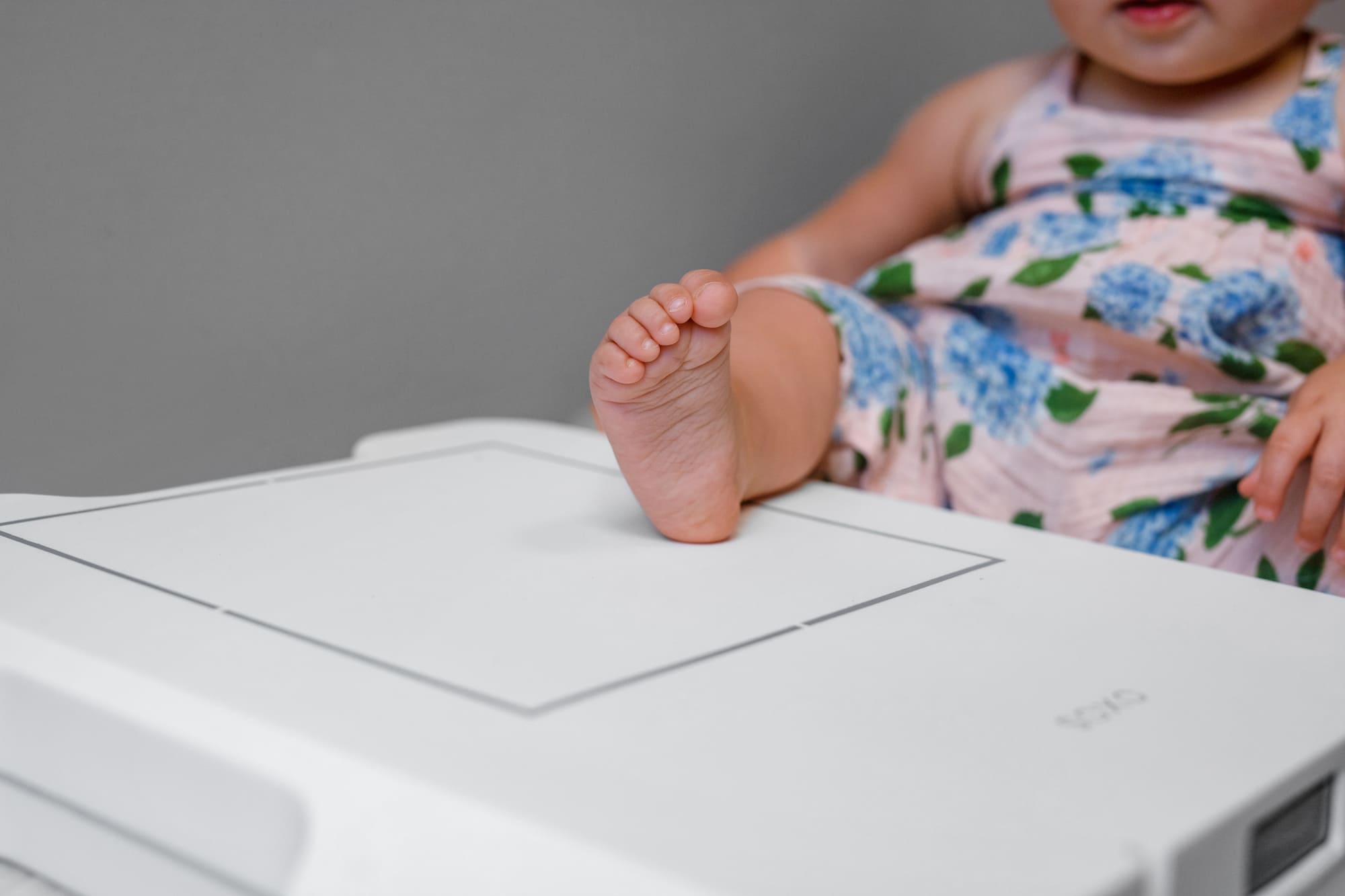 baby's foot is positioned in the center of the cassette for an X-ray